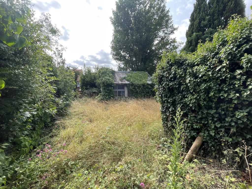 Lot: 133 - DETACHED BUNGALOW ON SIZEABLE PLOT WITH POTENTIAL - Outside image of rear garden and wooden workshop