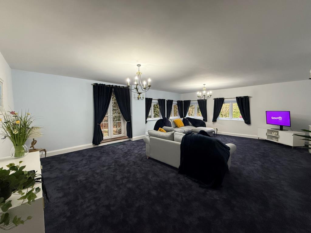 Lot: 59 - NEWLY REFURBISHED TWO-BEDROOM FLAT IN COASTAL LOCATION - Overview shot of carpeted lounge with doors to gardens