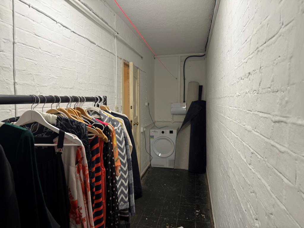 Lot: 59 - NEWLY REFURBISHED TWO-BEDROOM FLAT IN COASTAL LOCATION - Storage cupboard showing washer and further space