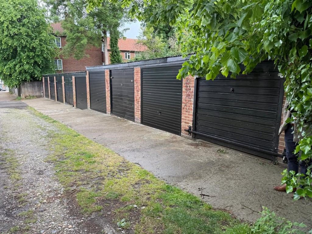 Lot: 19 - NINE FREEHOLD LOCK-UP GARAGES IN CENTRAL LOCATION - View of garages from top of driveway