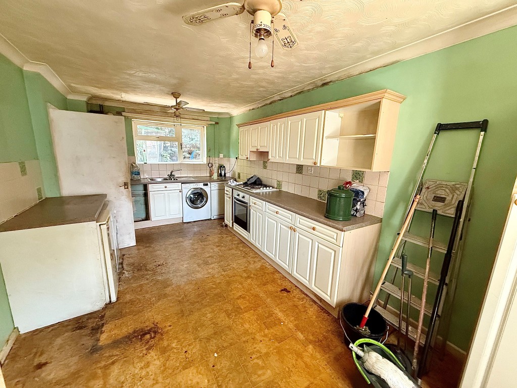 Lot: 99 - THREE-BEDROOM END-TERRACE HOUSE IN NEED OF MODERNISATION - Kitchen with fitted cabinets and window