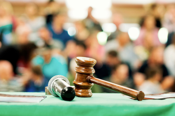 A gavel and a microphone sit on the table at an auction