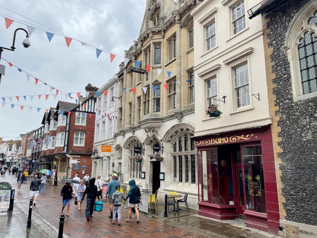 A red ground floor shopfront reads "boho". Above this sits various historic windows along the highstreet