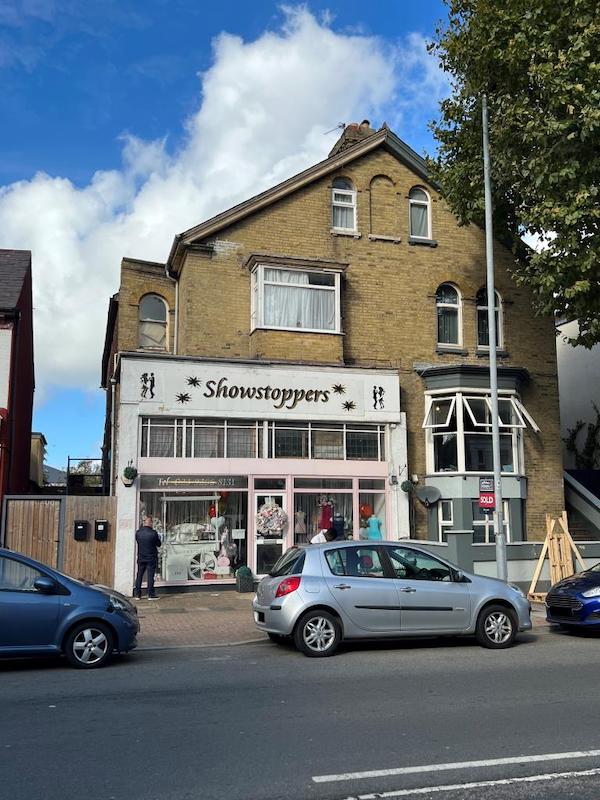 Lot 12, a commercial detached property, is pictured on a sunny day with a car out front